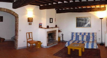 il soggiorno con camino dell'appartamento Siena nel podere Certino a Grotti Alto