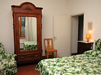 Una camera da letto dell'appartamento Oliveto che si affaccia sulla piazza di Saturnia, in Toscana